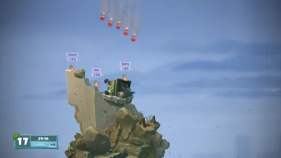 A scene from the video game Worms Battlegrounds, showing worms on a rocky terrain with bombs falling from the sky.