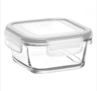 A clear glass food storage container with a gray lid and white clasps, isolated on a white background.