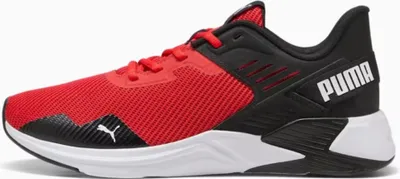 A side view of a red and black Puma athletic shoe.