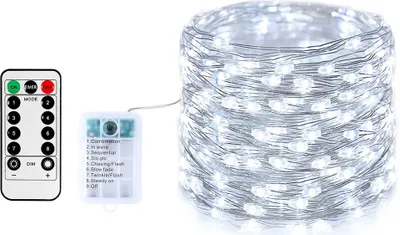 A string of white LED lights on a silver wire, next to a remote control and a battery pack.