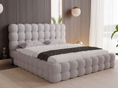 A modern bedroom with a light gray upholstered bed as the focal point.