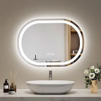 A modern bathroom vanity with a sink and an illuminated oval mirror above it.
