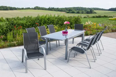 An outdoor patio setting with a dining set and a scenic landscape in the background.
