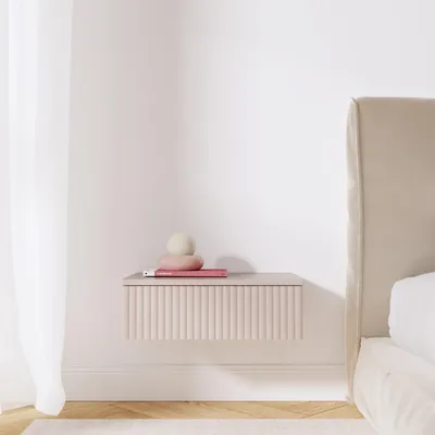 A minimalist bedroom scene with a floating nightstand next to a bed.