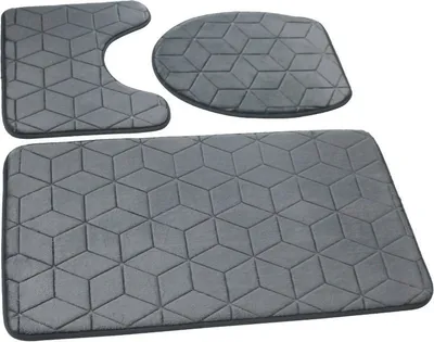 Three grey bathroom mats with a geometric cube pattern are arranged on a white background.