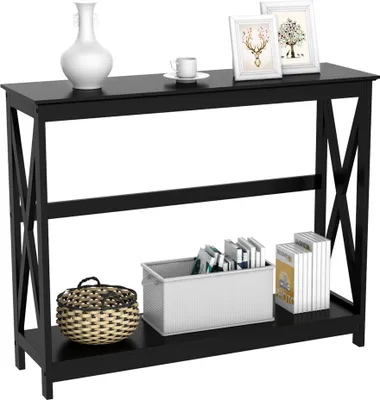 A black console table with two shelves, decorated with a vase, a cup, picture frames, a basket, and books.