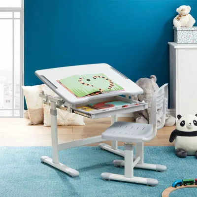 A child's desk and chair set in a room with toys and pillows.