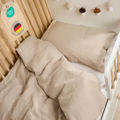A close-up view of taupe-colored children's bedding in a crib.