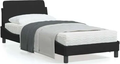 A black bed frame with a mattress, pillow, and blanket.