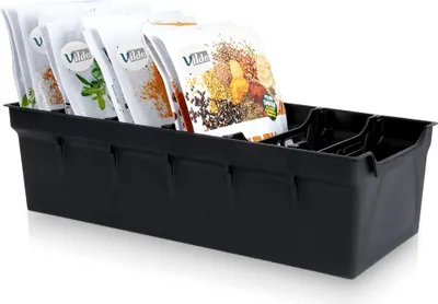 A black plastic organizer tray holding several small bags of spices or seeds.