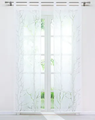 Two sheer white curtains with a green branch pattern hang in front of a window.