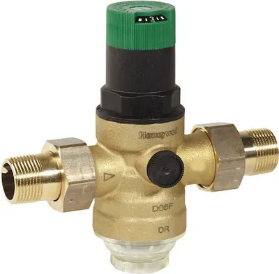 A brass pressure reducing valve with a green and black adjustment cap.