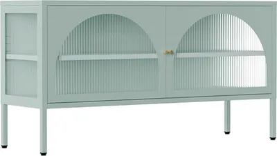 A sage green metal TV cabinet with two arched doors featuring fluted glass and brass handles, shown against a white background.