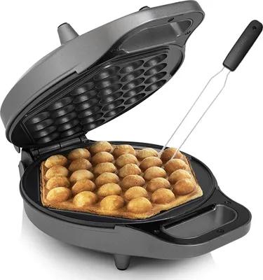 A bubble waffle maker with a waffle being cooked inside, and a fork is being used to remove it.