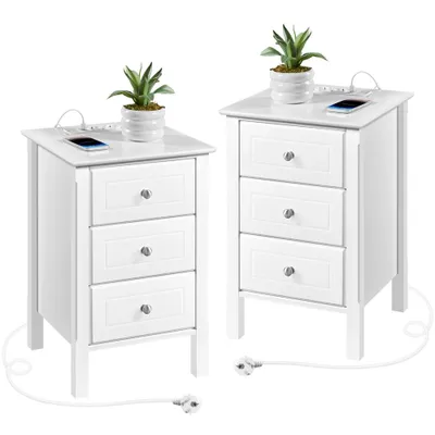 Two white nightstands with built-in charging ports and USB ports, each topped with a small potted plant and a smartphone.
