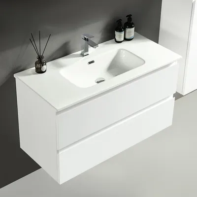 A white bathroom vanity with a sink and faucet, set against a dark gray wall.