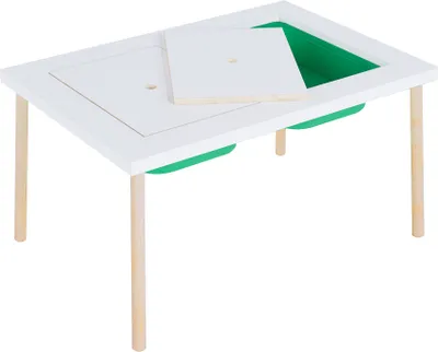 A white children's table with green storage bins underneath and a wooden lid partially covering the table surface.