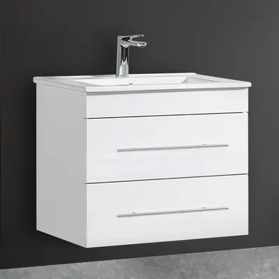 A white bathroom vanity with a sink and faucet against a dark gray wall.