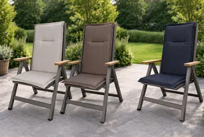 Three outdoor chairs with cushions on a patio.