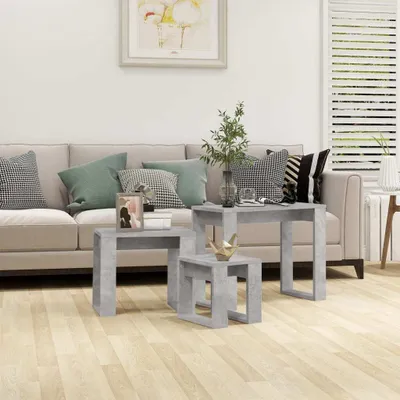 A living room scene with a sofa, pillows, and nesting tables.