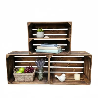 Three wooden crates are arranged to form shelves, with decorative items and folded linens placed on them.