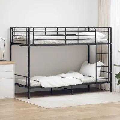 A black metal bunk bed with mattresses and white bedding in a room with light wood floors and a white rug.