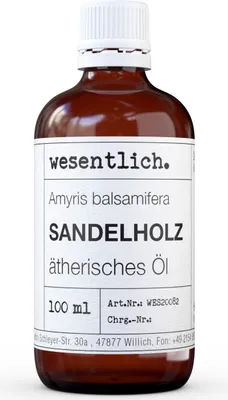 A brown glass bottle of essential oil with a white label.