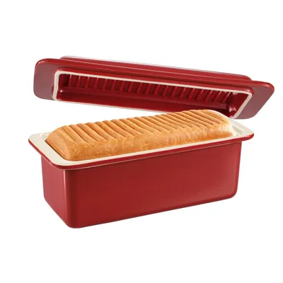 A red loaf pan with a loaf of bread inside and its lid slightly ajar, set against a white background.