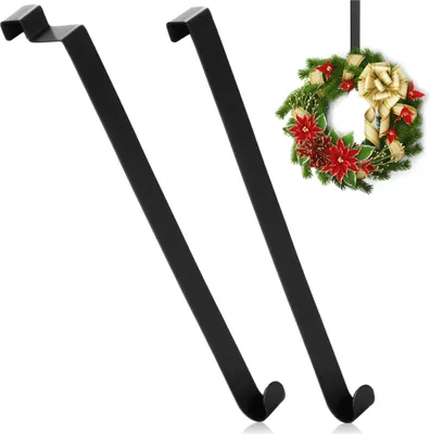 Two black metal wreath hooks are shown against a white background, with a decorated Christmas wreath hanging from one of them.