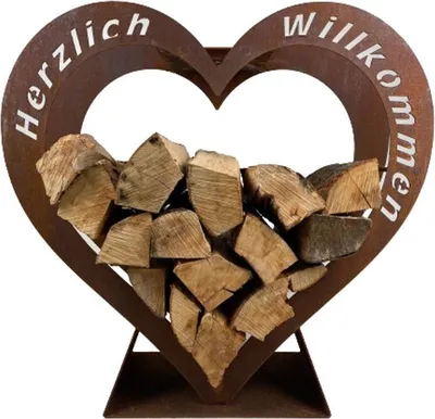 A heart-shaped metal firewood rack filled with logs, with German text on the frame.