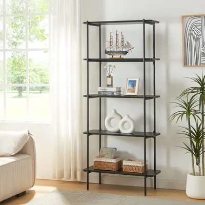 A black metal bookshelf with five shelves is displayed in a well-lit room with a large window and a sofa.