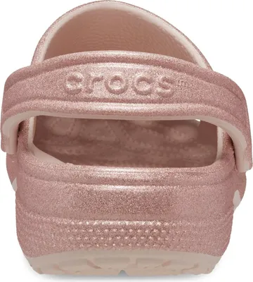 A close-up back view of a pink glitter Croc shoe.
