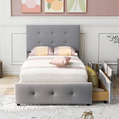 A grey upholstered bed with a tufted headboard and a pull-out drawer is shown in a bedroom setting.