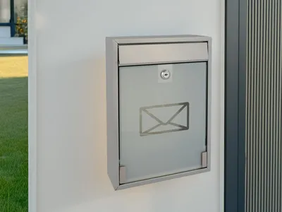 A modern mailbox mounted on a white wall.