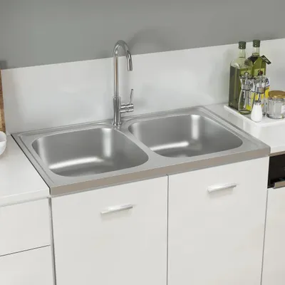 A double sink with a faucet is installed in a white cabinet.
