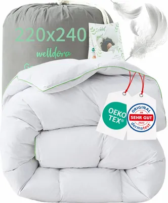 A white down comforter is folded and presented in a grey drawstring bag, with decorative elements like feathers and certification tags.