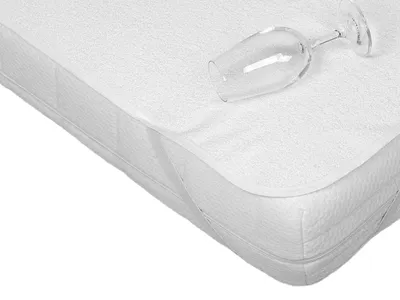 A close-up view of a white mattress protector with a wine glass placed on top.