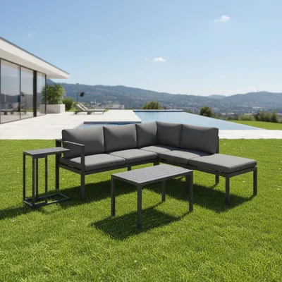 An outdoor living space with a modern house, swimming pool, and mountains in the background, featuring a gray sectional sofa and coffee tables on a green lawn.