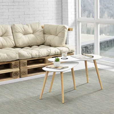 A living room scene with a pallet couch and nesting coffee tables.