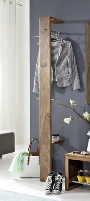 A hallway or entryway scene with a coat rack, jacket, bag, shoes, and decorative items.