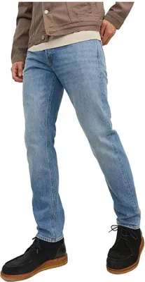 A person wearing jeans and shoes, shown from the waist down.