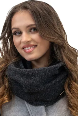 A woman wearing a dark grey loop scarf.