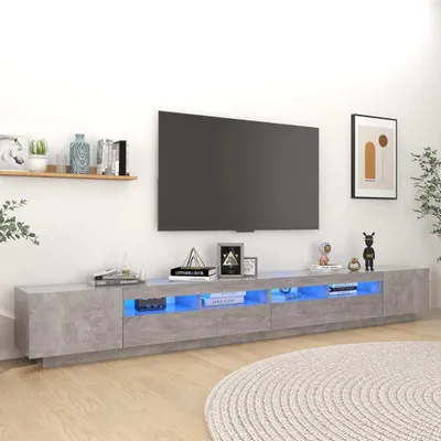 A modern living room with a TV stand and a large television mounted on the wall.