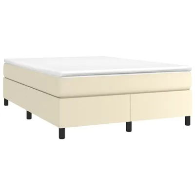 A studio shot of a boxspring bed frame with a mattress topper.