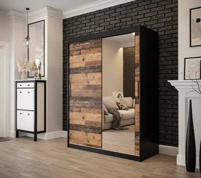 A modern hallway with a sliding door wardrobe with wood and mirror panels, a shoe cabinet, and a brick wall.