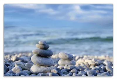Produktbild von Wallario Frühstücksbrettchen aus Glas 20 x 30 cm mit rutschfesten Füßen, Motiv Steinstapel am Strand