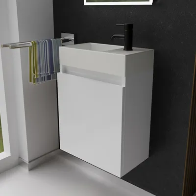 A modern bathroom vanity with a sink and faucet, set against a dark textured wall.