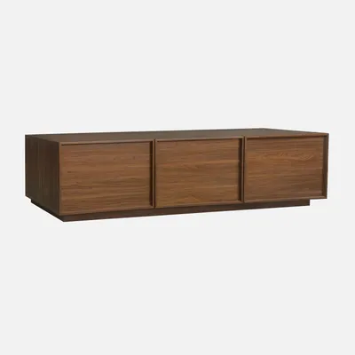 A wooden TV stand with three doors against a plain background.