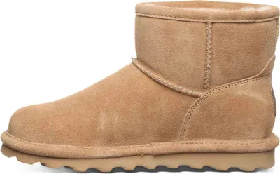 A side view of a single beige boot.