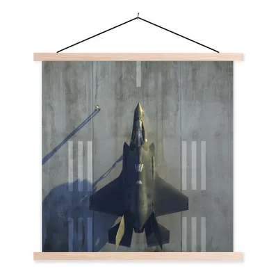 Produktbild von MuchoWow® Textilposter Der F-35 Lightning II Jet am Boden 120x120 cm mit holzfarbenen Rahmen - Textil-Poster